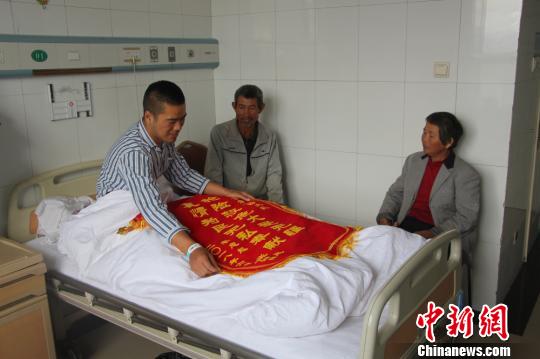 被救的李忠起、張總鳳夫婦看望受傷后的李運(yùn)飛?！⊥粲?攝