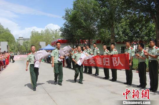 部隊(duì)官兵們迎接出院歸來的李運(yùn)飛(中)和其他消防戰(zhàn)士。　汪渝 攝
