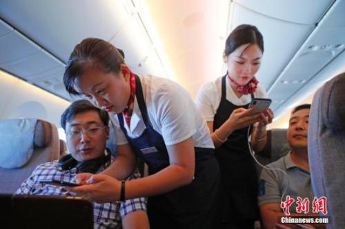 資料圖：乘務員們在客艙內為旅客調試機上上網(wǎng)功能。<a target='_blank' ><p  align=