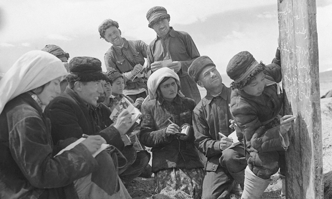 1960年6月，新疆慕士塔格峰下，大人們在小學生幫助下學習文化。新華社記者武純展攝