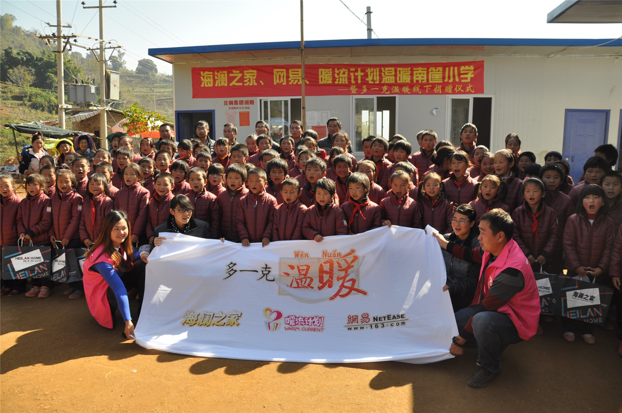 2014年11月20日，“多一克溫暖”公益團(tuán)隊來到8.3大地震的重災(zāi)區(qū)——云南省昭通市魯?shù)榭h的南筐小學(xué)。越過崎嶇山路，將一批又一批暖心羽絨服送到了師生們的手中，也將社會的關(guān)懷和愛意傳遞給了這些可愛的人。